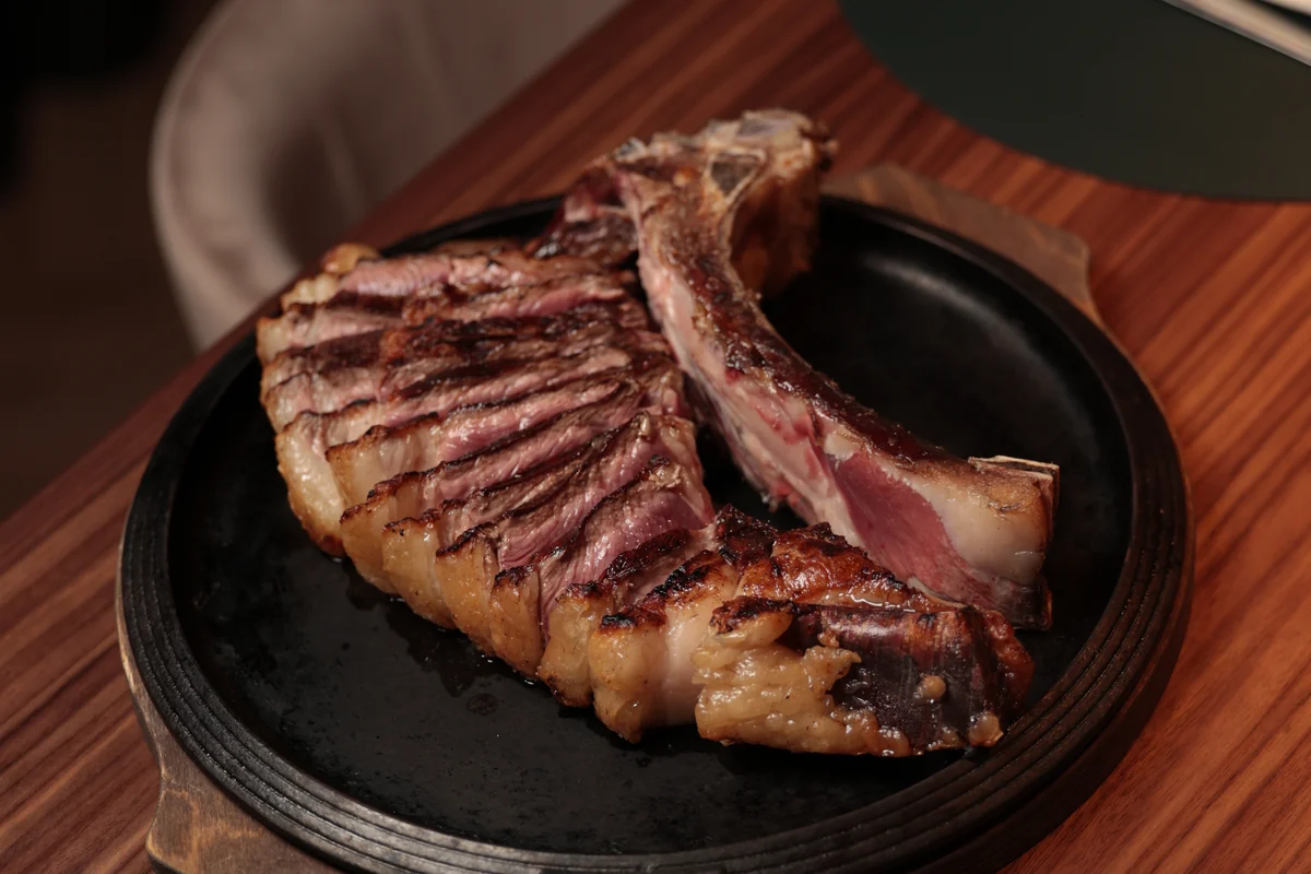 Costata alla brace tagliata e servita al tavolo su piastra di ghisa, Nonna Pina