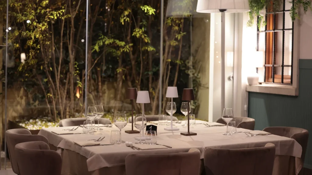 Tavolata apparecchiata nel giardino d'inverno del Ristorante Nonna Pina
