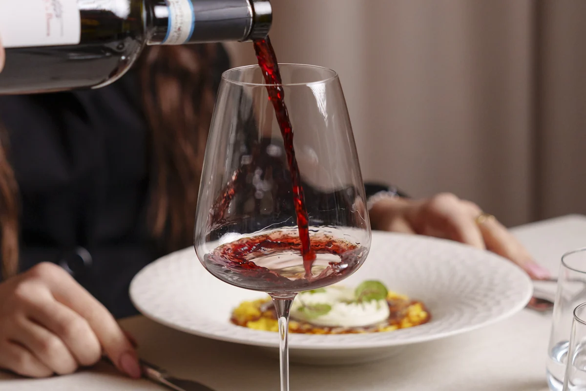 Vino rosso versato nel calice a tavola, Ristorante Nonna Pina